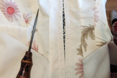 preparing to open the eyelet holes with an awl